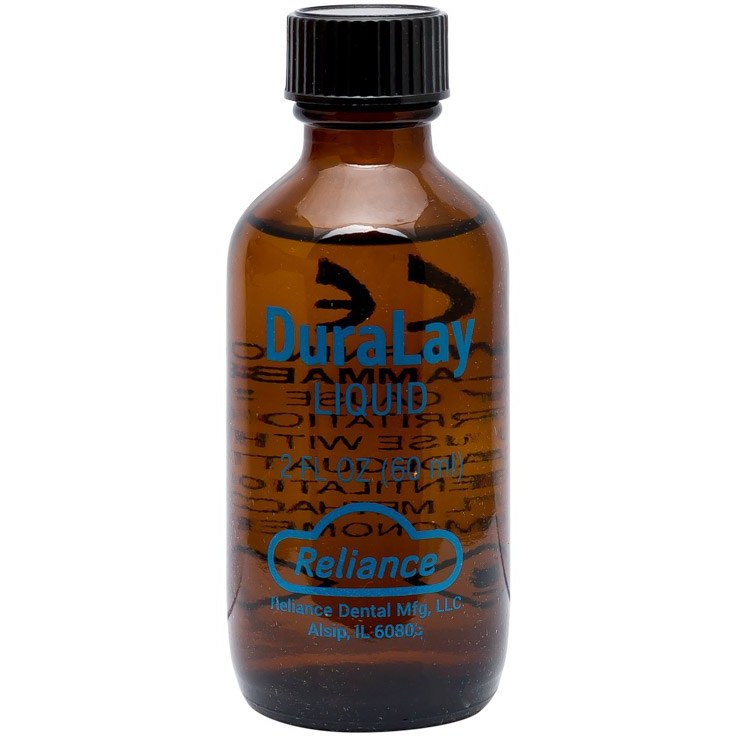 مایع آکریل دورالی ریلانس Reliance Duralay Liquid | بطری شیشه‌ای یا پلاستیکی شفاف با برچسب قرمز و برند Reliance آمریکا، کنار ظرف پودر قرمز دورالی و ابزار کار قالبگیری، زمینه سفید | panamal.ir